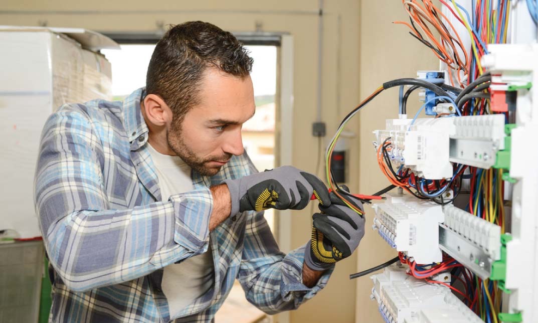 Commercial and domestic electrician carrying out electrical work in Devon